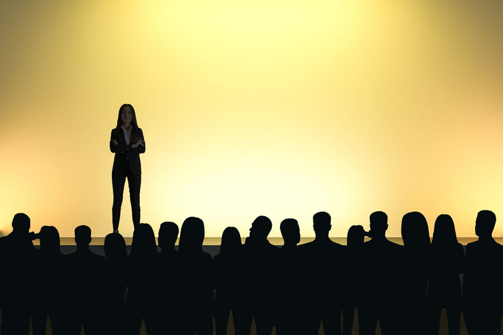 Businesswoman giving speech in front of backlit audience on light yellow background. Speaker and motivation concept